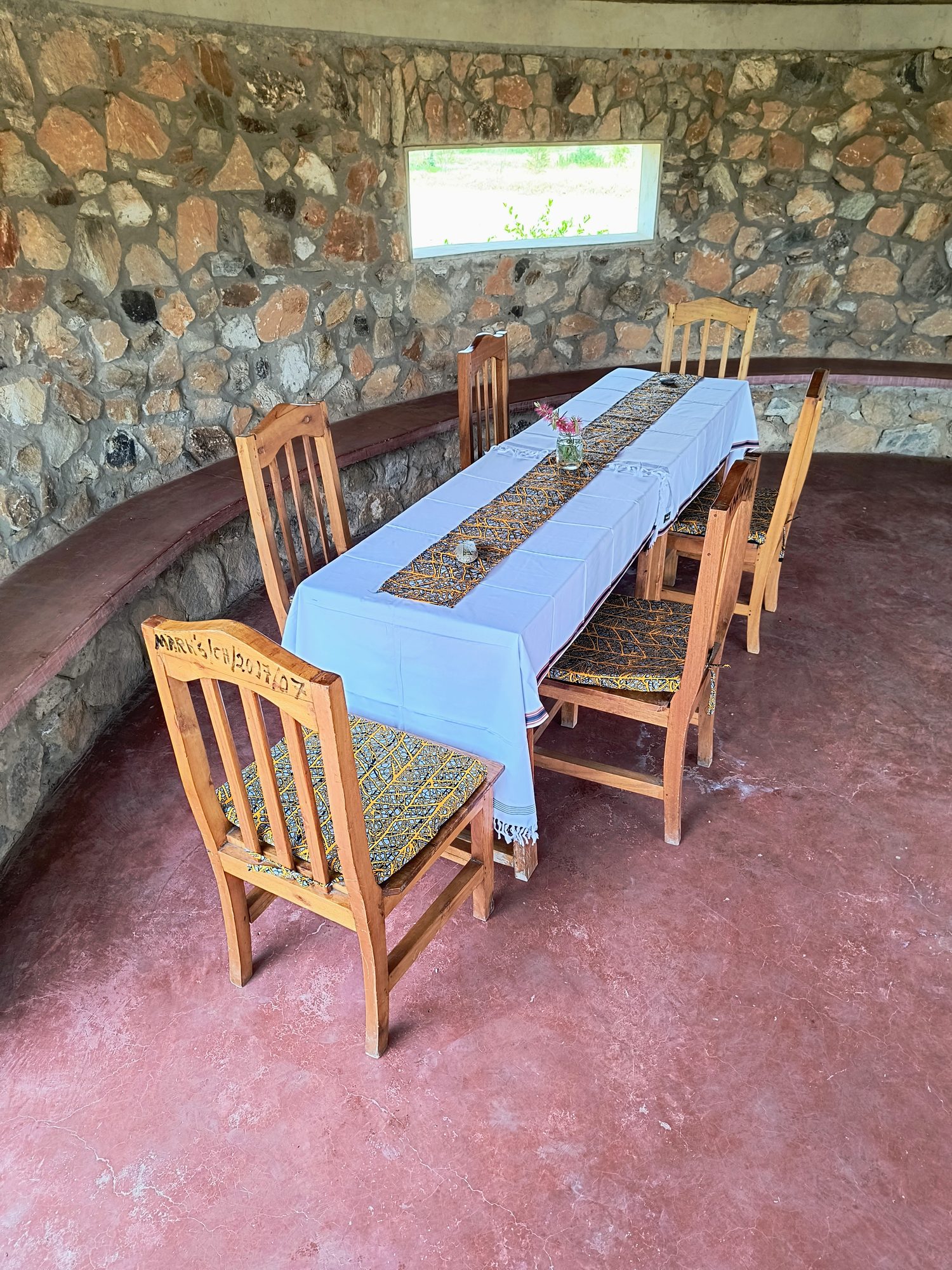 Dining room in the stone building with a long table set for guests