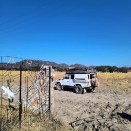 Overland vehicle with a rooftop tent at the gate of the campsite near Iringa