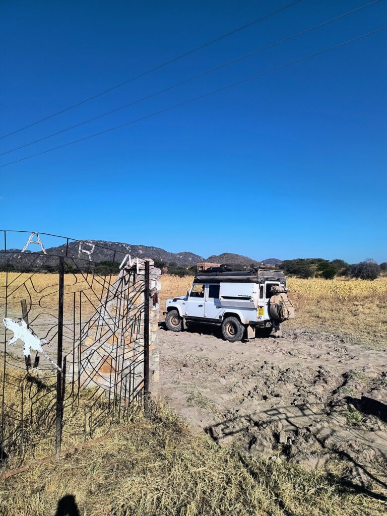 Overland vehicle with a rooftop tent at the gate of the campsite near Iringa