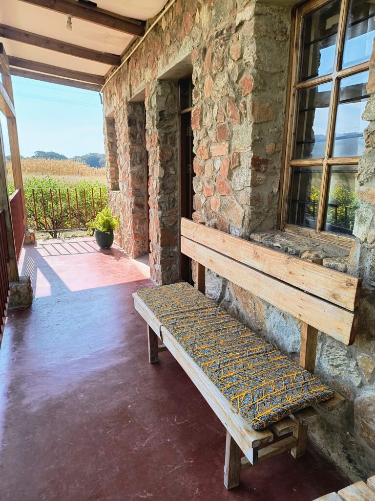 Stone veranda with wooden benches and cushions