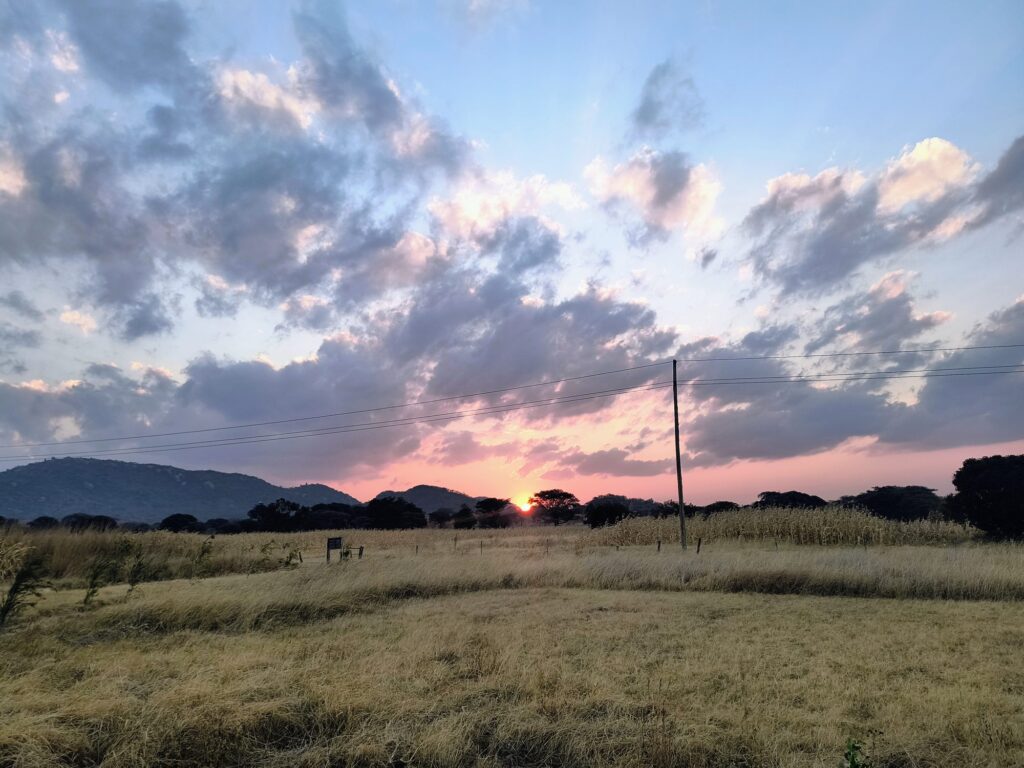 Pink and grey clouds at sunset over the grassland and mountains near Iringa