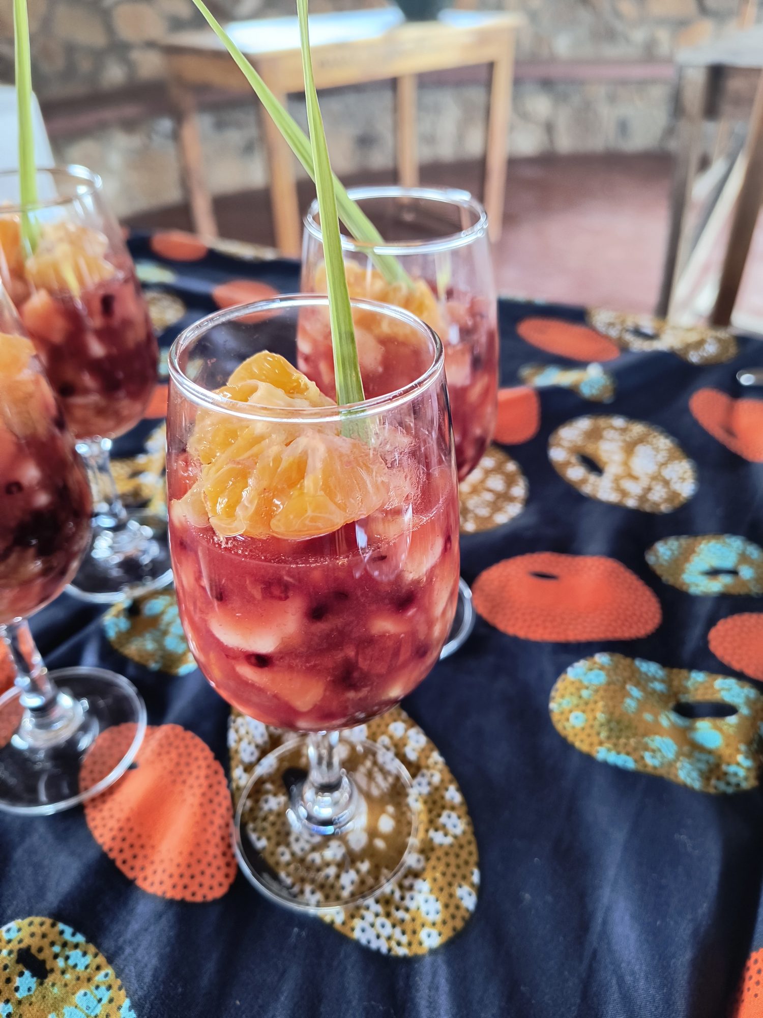 Welcome drink with fresh fruit and a straw on a kitenge tablecloth